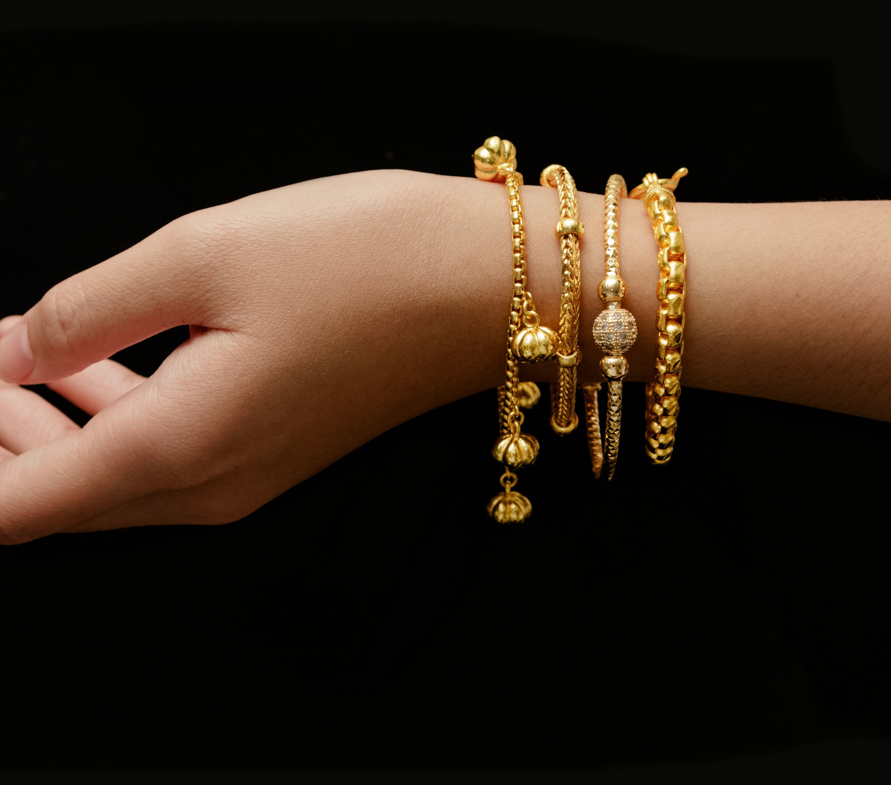Gold Armbänder an Hand